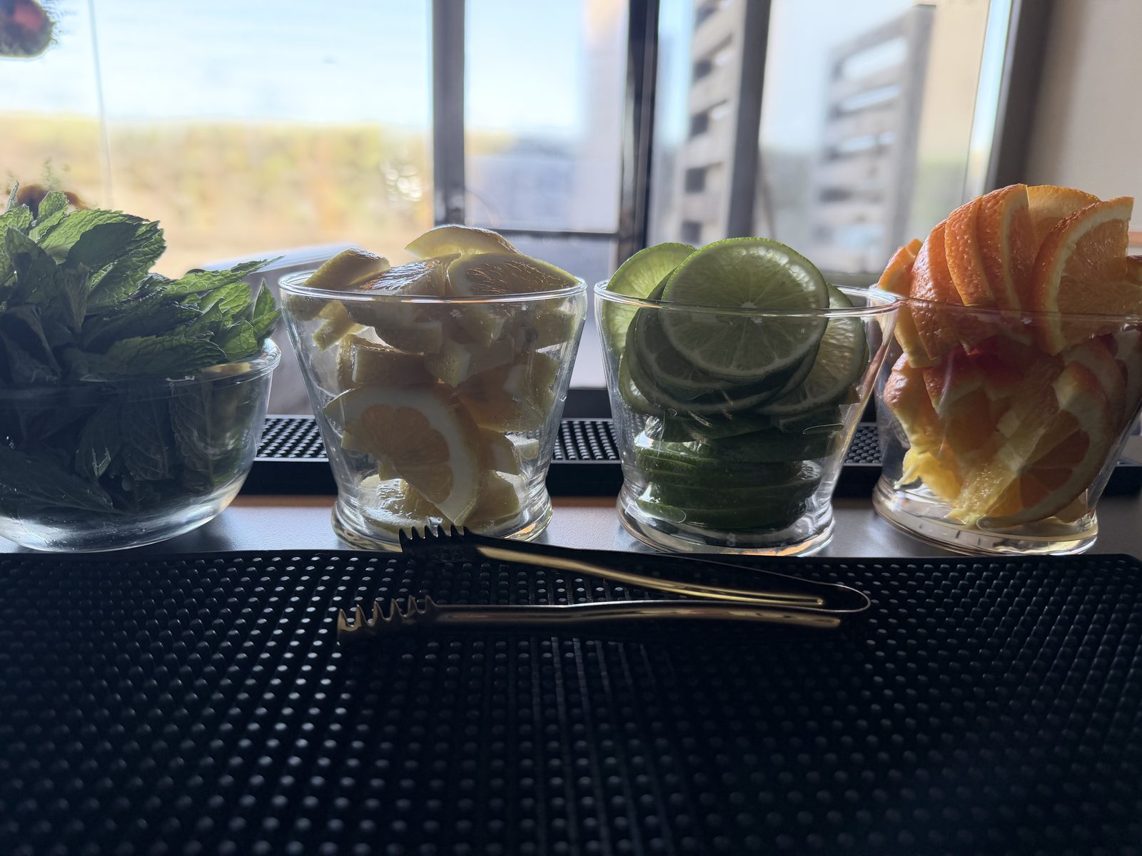 Three She Pours branded signature cocktails with fresh garnishes.