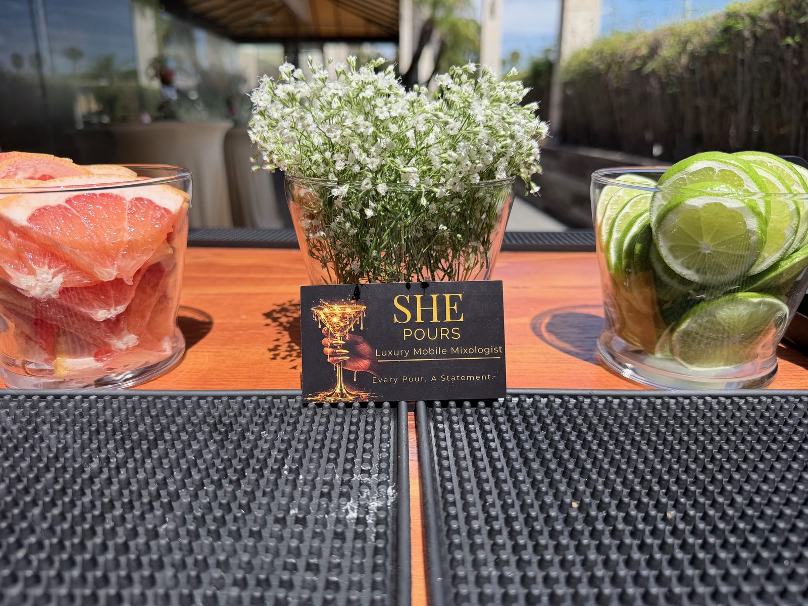 A garnish bar setup with mint, citrus wheels, and gold tongs.